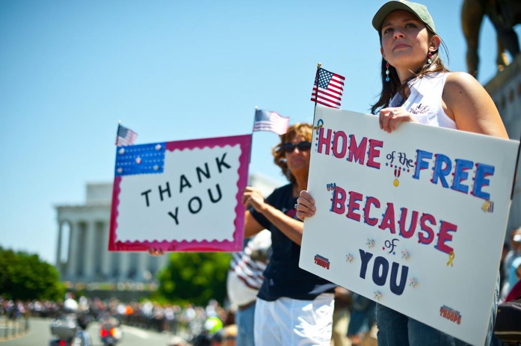 Two women hold up signs thanking the troops as members of the US military veterans' Rolling Thunder bikers group ride past in Washington on May 26, 2013 as the country marks Memorial Day. AFP PHOTO/Nicholas KAMMNICHOLAS KAMM/AFP/Getty Images ORG XMIT: US-VIETNA